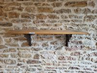 Une étagère plateau bois avec deux anneaux en acier travaill…