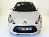 a small white car that is parked in a room