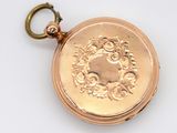 a gold pocket watch on a white surface