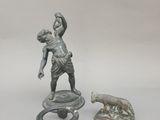 une statue représentant un homme tenant un bébé sur un tabouret