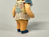 a teddy bear that is wearing a hat and a dress