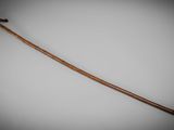 a close up of a wooden stick with a handle on a white surface