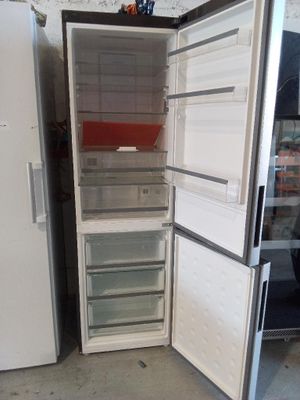 un réfrigérateur blanc dont la porte est ouverte, dans un garage