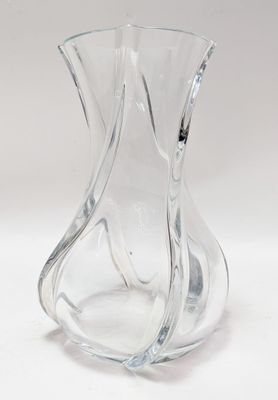 un vase en verre transparent posé sur une surface blanche