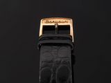 a black alligator skin watch strap with a gold buckle