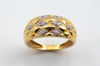 gros plan d'une bague en or avec des diamants sur fond blanc