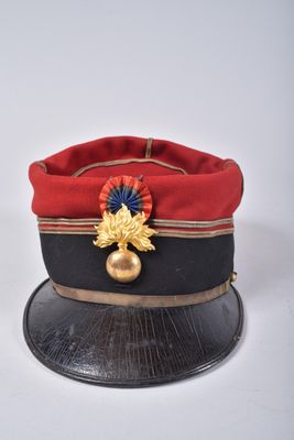 un chapeau rouge orné d'une feuille d'or
