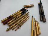 de nombreux types de stylos et de crayons disposés sur une table