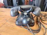 a black telephone sitting on a wooden table