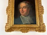 a painting of a man in a gold frame on the wall