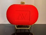 une photo d'un sac à main rouge posé sur une table noire