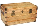une vieille malle en bois posée sur une surface blanche