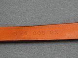 a close up of a brown leather belt on a gray surface