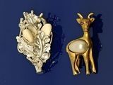 deux broches sur un fond bleu : l'une représente un cerf et l'autre un cerf