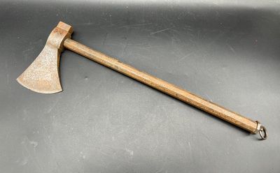une vieille hache au manche en bois posée sur une table