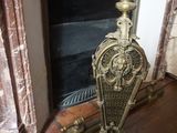 une horloge en or posée sur un socle devant une cheminée