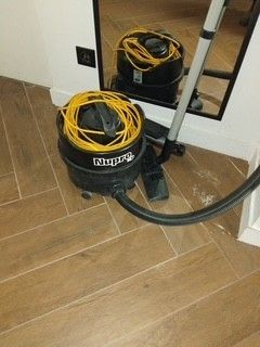 a vacuum that is sitting on the floor next to a mirror