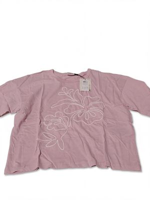 the shirt is pink and has white flowers on it
