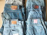 deux paires de jeans bleus posées sur une boîte en carton