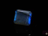 a close up of a blue stone on a black surface