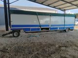 a blue and white trailer that is parked in the dirt