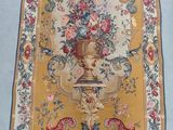 a rug with a vase of flowers on it on a bed