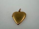 a gold heart shaped locke on a white surface