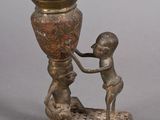 a bronze statue of a man and a child holding a vase