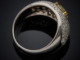 a close up view of a ring with a yellow sapphire and diamonds