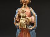 an old statue of a man holding a baby in his arms