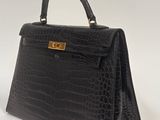 a black crocodile skin handbag with gold hardware