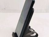 a cell phone that is on a stand on the table