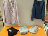 un lit sur lequel sont posés des vêtements et une veste accrochée au mur