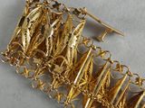 gold plated bracelet with gold leaf charms on a white surface