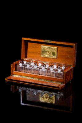 a wooden case with several glasses in it on a black surface