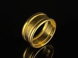 a close up of a gold ring on a black surface