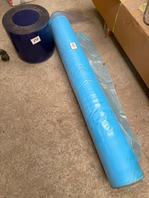 un rouleau de plastique bleu posé par terre à côté d'une boîte