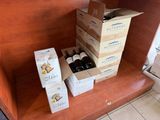 Plusieurs cartons de vin sont empilés sur une étagère dans une cuisine