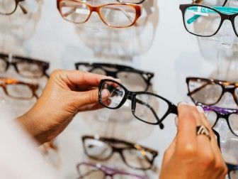 une femme qui regarde des lunettes dans un magasin