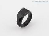 a black ring on a white surface with a black stone in the middle