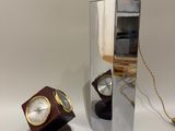 un miroir sur lequel est fixée une horloge et une lampe posée sur une table
