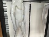 un mannequin blanc devant un miroir, dans une pièce