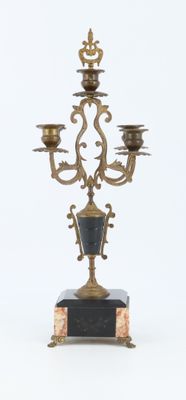 a gold and black candelab with three candles on it