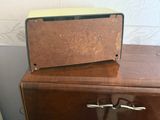 a brown suitcase sitting on top of a wooden cabinet