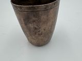 a metal cup that is sitting on a table