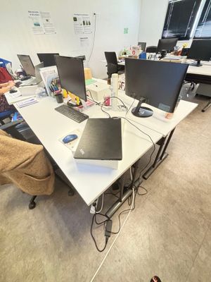 un homme assis à une table sur laquelle se trouvent deux ordinateurs portables