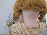 a close up of a doll with red hair and scissors