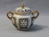 a white and gold teapot with a gold lid