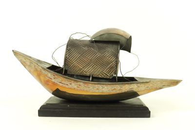 a wooden boat with a hat on top of it