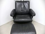 an image of a black leather recliner chair and ottoman in a white room